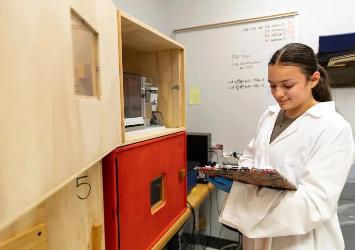 student with clipboard in lab