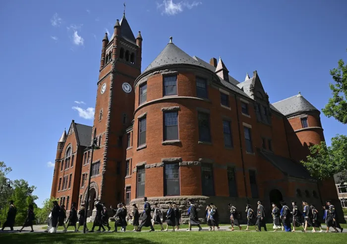Graduates walk past the Glatfelter building.