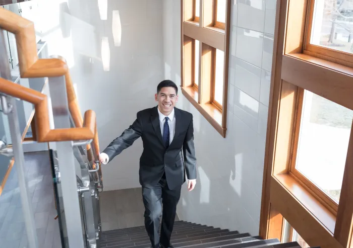 student in business attire walks up steps