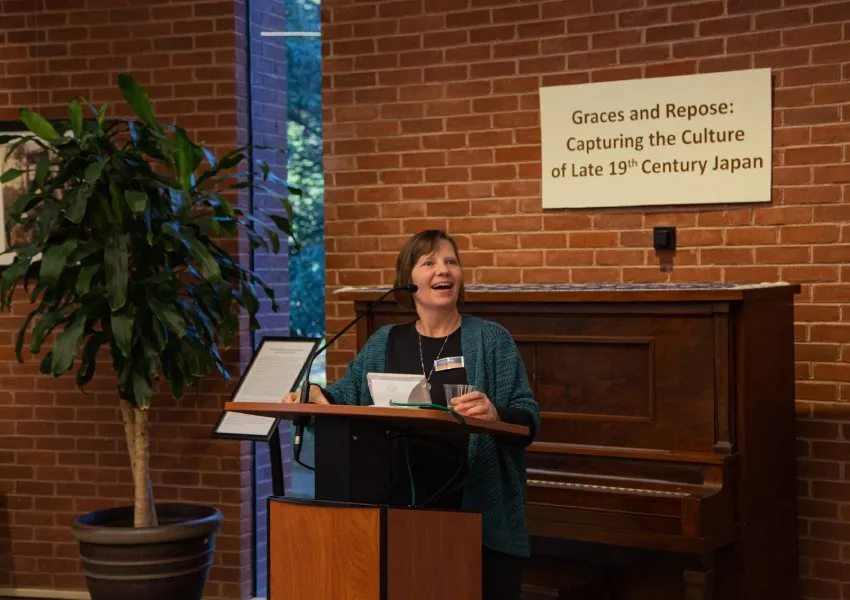 speaker at podium in front of piano