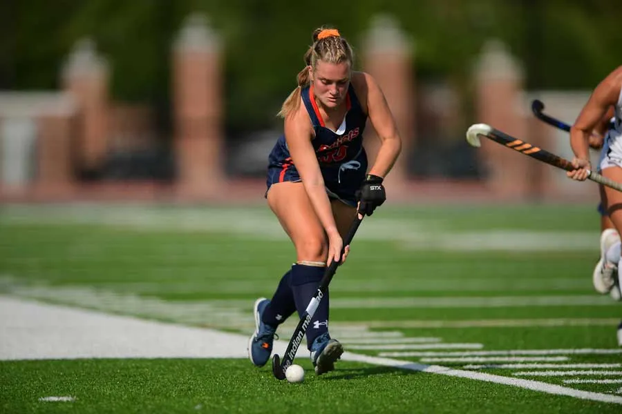 Charlotte Lacey playing Lacrosse on the field