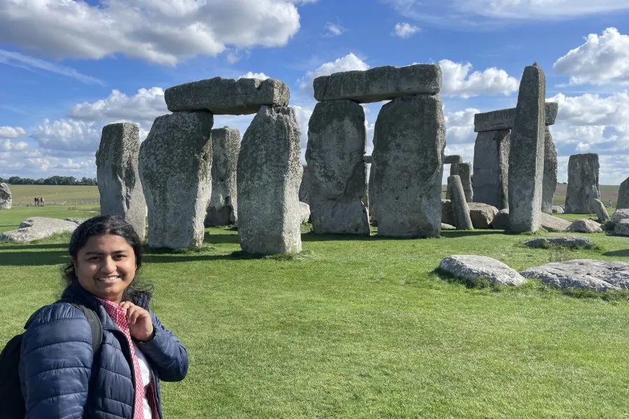 female student poses in front of Stonehenge