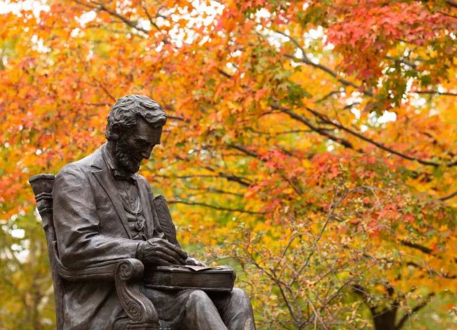 statue of Abe Lincoln with fall foliage in background
