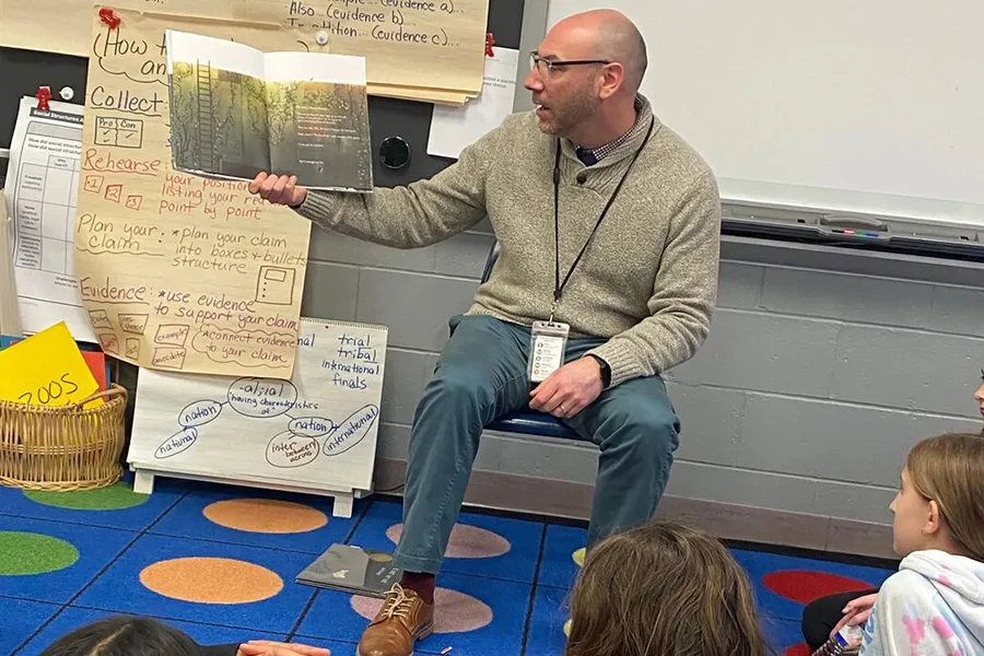 Hart reads to children at his school
