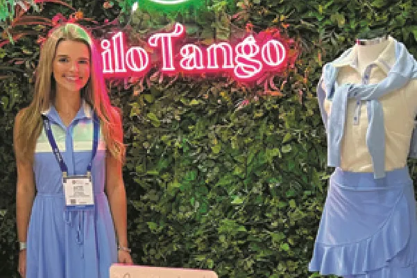 A phot of Katie McCarthy stading in front of a light-up sign reading, Kilo Tango.
