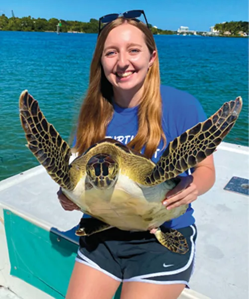 Photograph of Bethany Holtz holding a large turtle