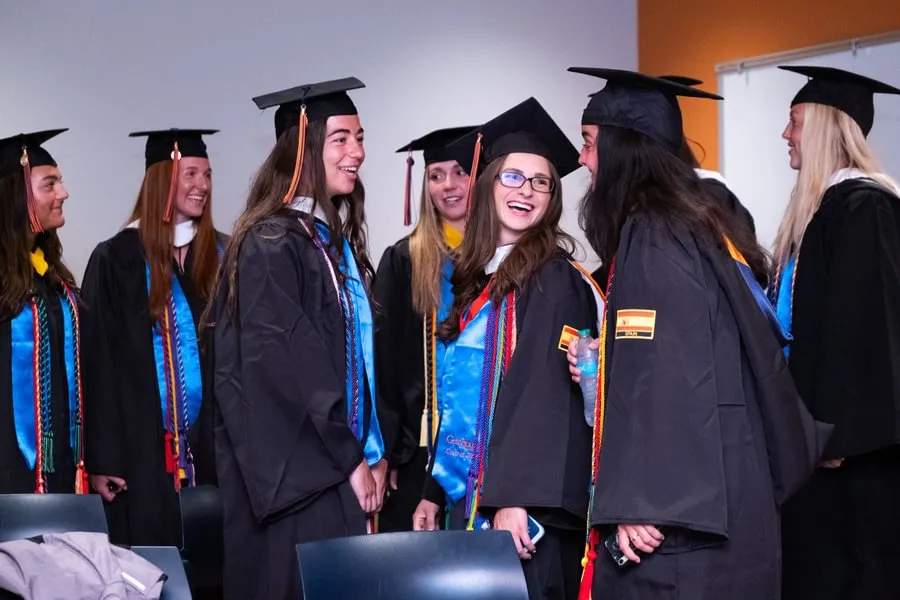 Softball seniors Alyna Balewitz and Carlie Goldstein laugh with lacrosse senior Izzy Chiperfield before Special Commencement.