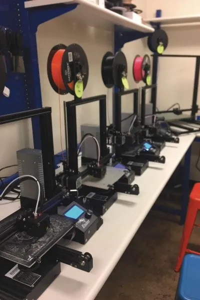 3D printers with filament spools on a workbench