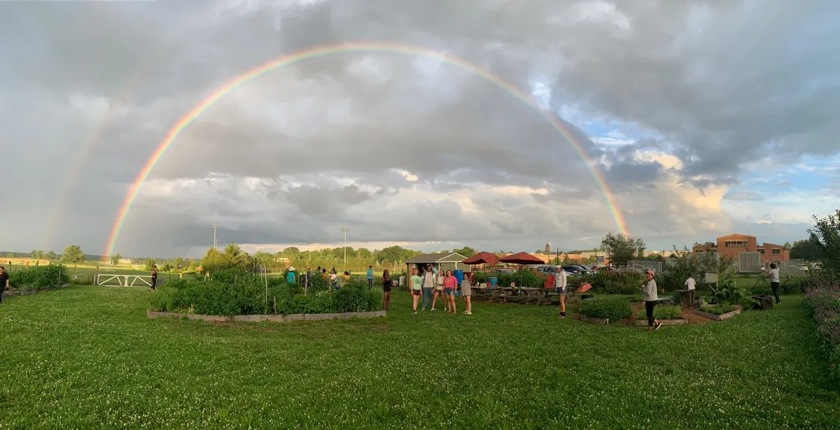 students pose under double rainbow at Painted Turtle Farm