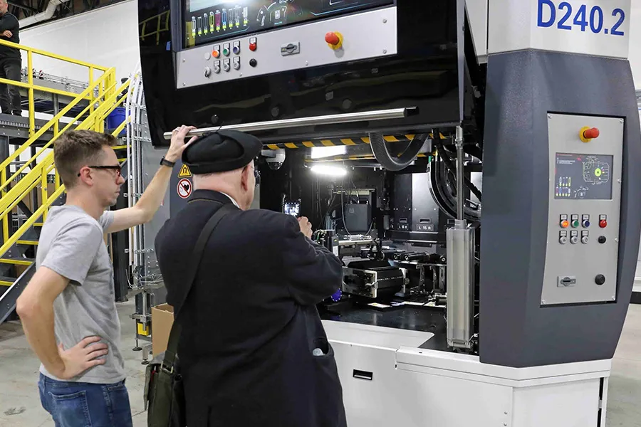 Two men in front of a machine