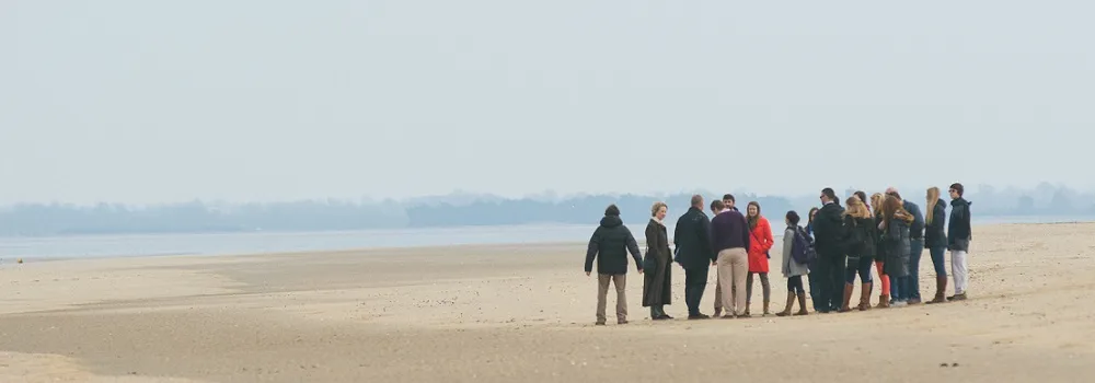 A group of people standing on a beach.
