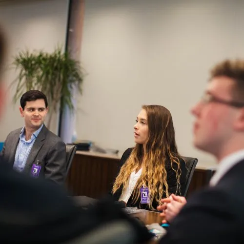 People seated at a meeting table.