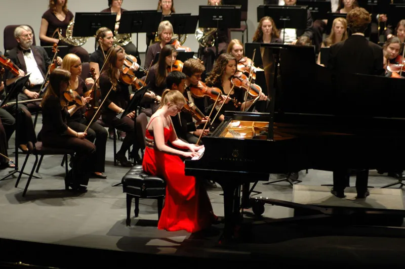 Pianist performs with an orchestra during a concert.