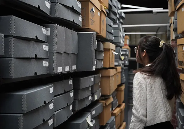 Person walking through a narrow archive aisle.