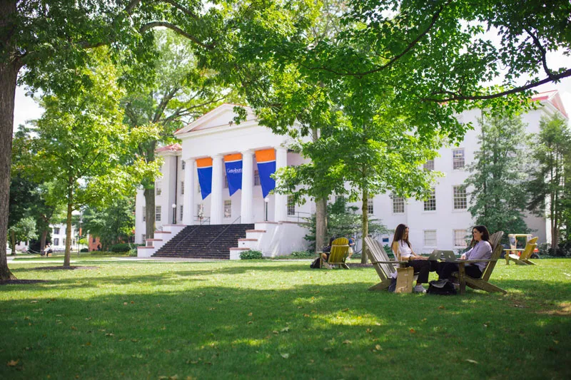 Two students sit in the grass outside Pennsylvania Hall.