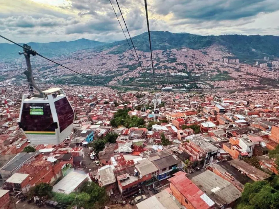 A photo of a cable car traveling over Medellin.