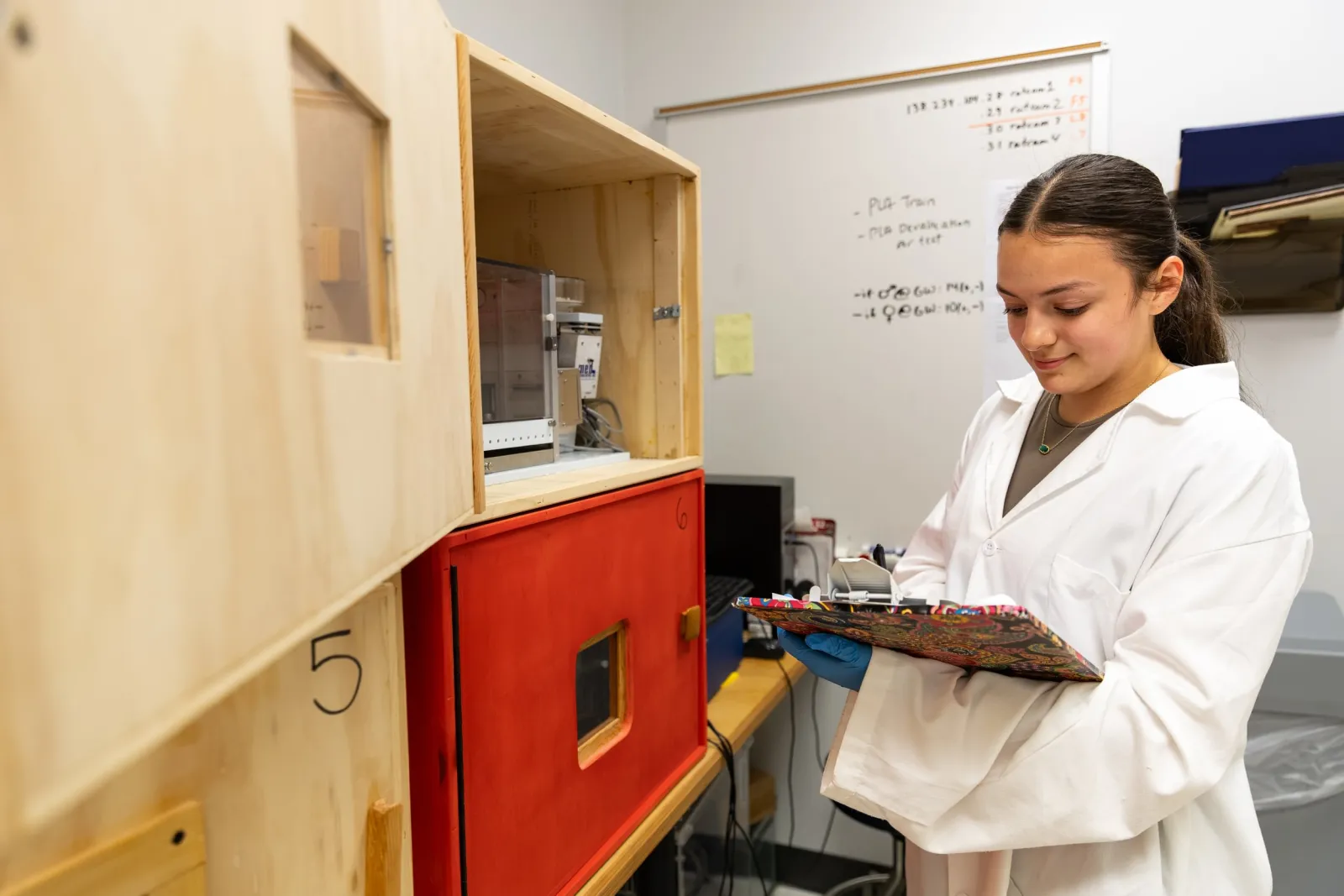 student in lab with clipboard