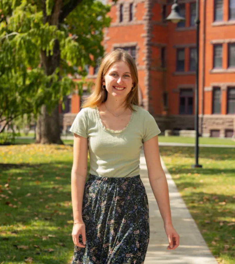 Ainsley Green walks on campus with brick building behind her