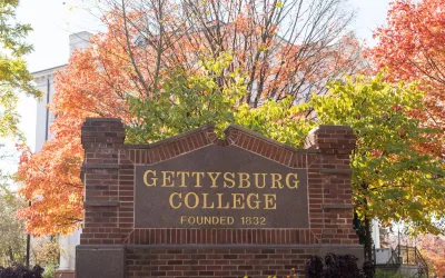 Gettysburg College sign on Washington Street with fall foliage in background