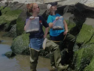 Two students proudly display the items they discovered during their research.