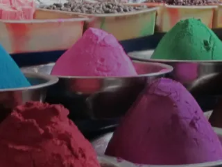 Colorful powdered pigments in metal bowls.