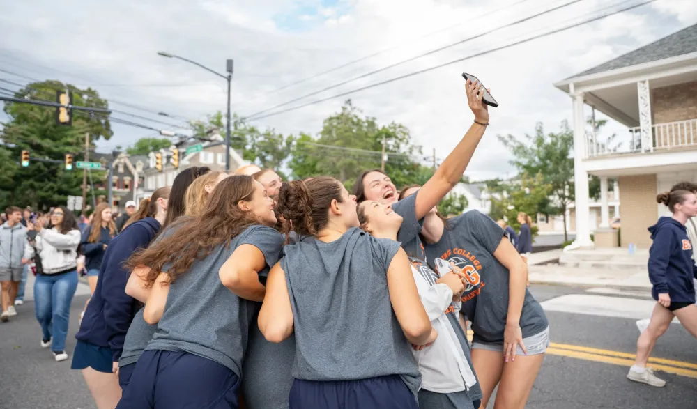 students pose for selfie in the street