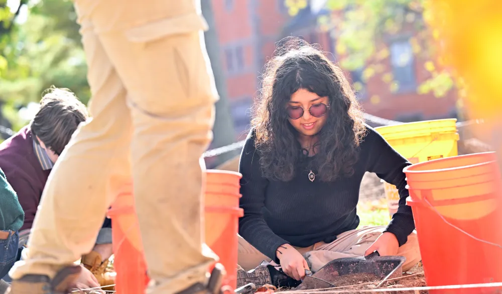 student sifting dig materials