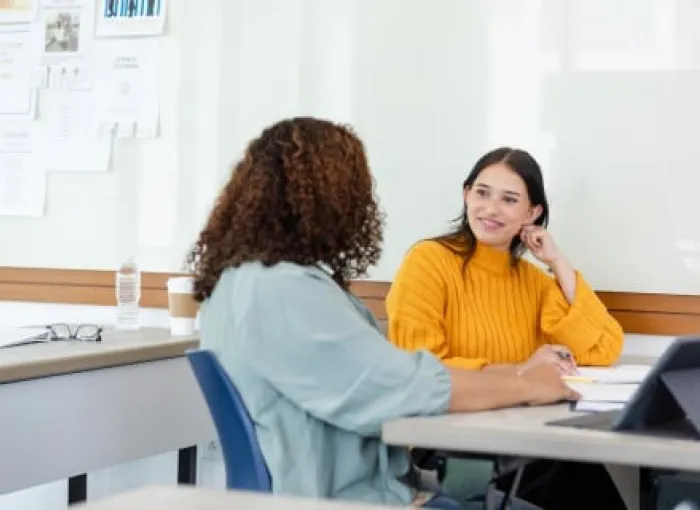 Two ladies in the classroom discussing