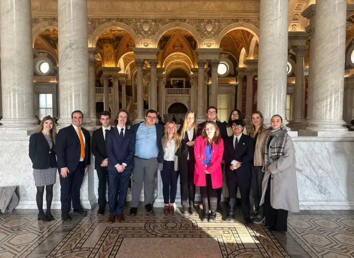 students in professional attire in ornate lobby of building