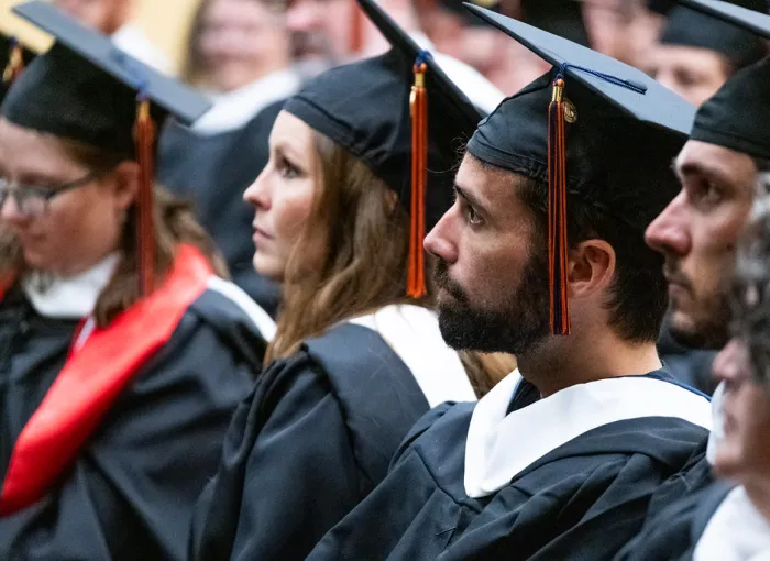Graduates in caps and gowns during a ceremony.