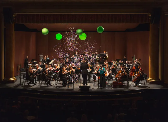 An orchestra performs in a concert hall.