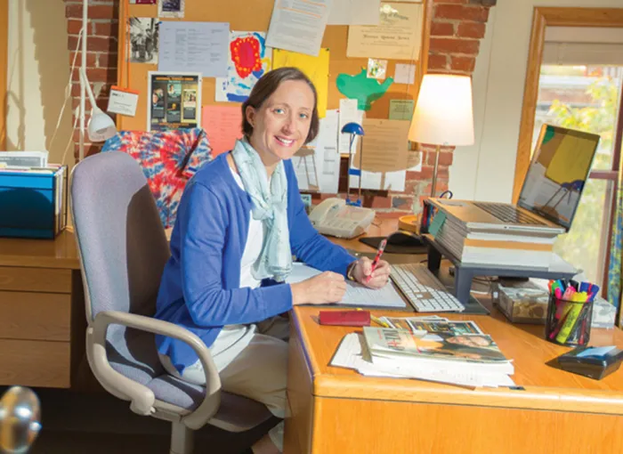 A professor sits at her desk.
