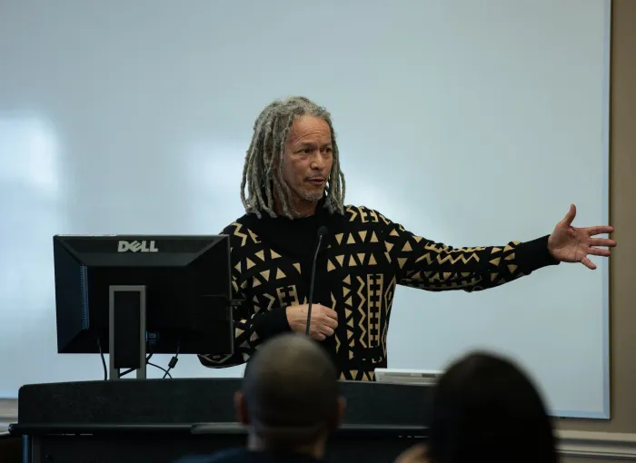 Professor gestures at front of class