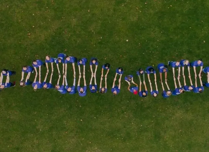 aerial of students linking hands to create double-helix