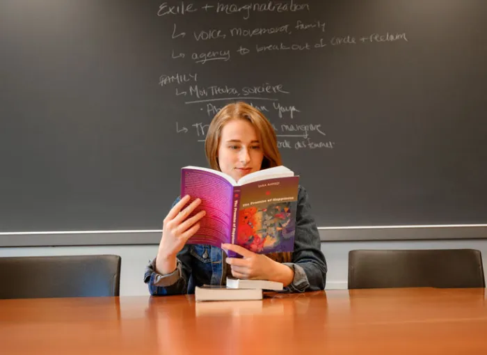 A student sits in a classroom reading.