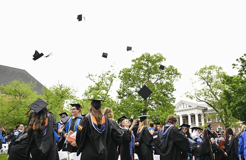 A group of graduates throwing their hats up in the air
