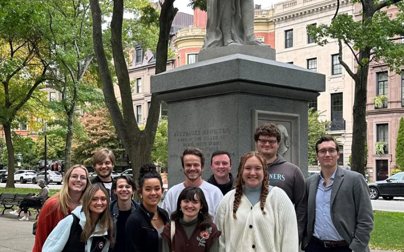 Political Science majors standing in front of a statue om Boston