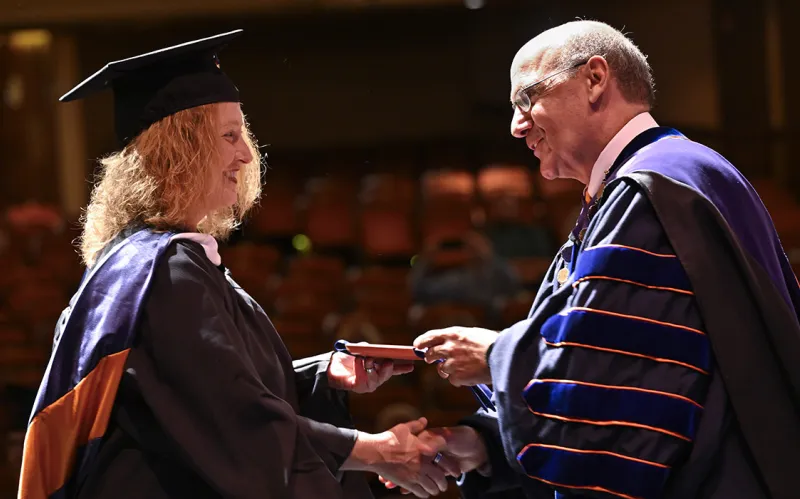 Gettysburg College President Bob Iuliano presents a Stole of Gratitude to a graduate 