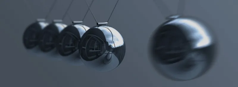 silver balls dangle from suspension wires and reflect foreground